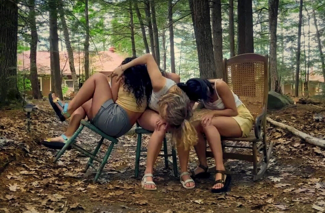 3 Dancers intertwined on sitting on chairs in the forest